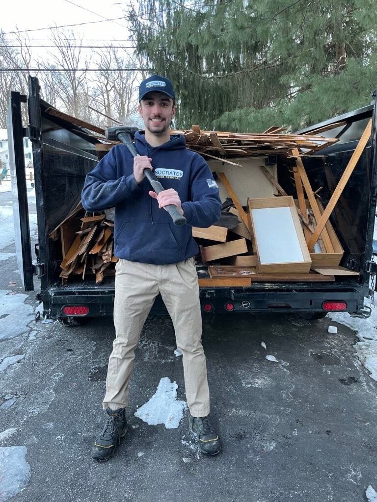 Socrates Junk Removal owner in front of loaded dump trailer after junk removal job