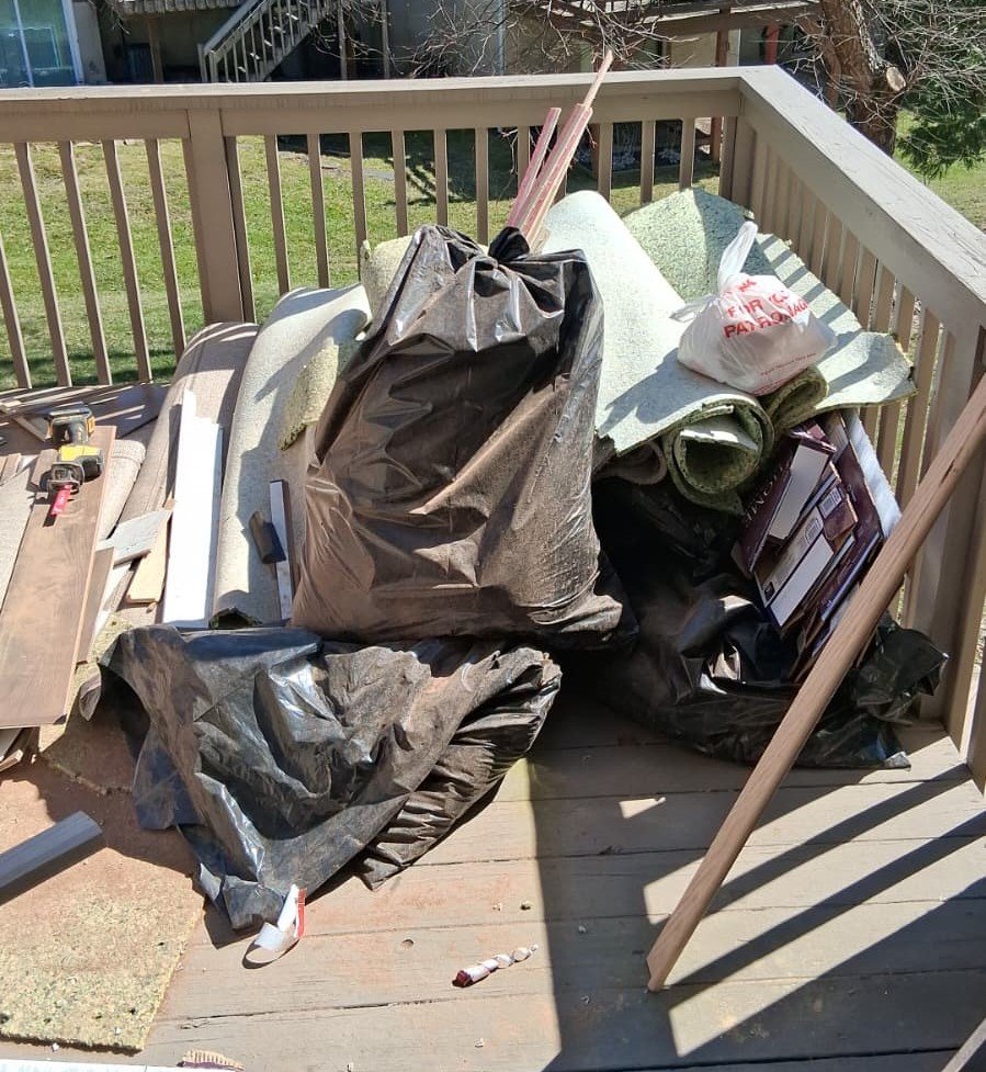 construction debris removal in Wayne PA wood scraps flooring and trash bags on deck before junk removal