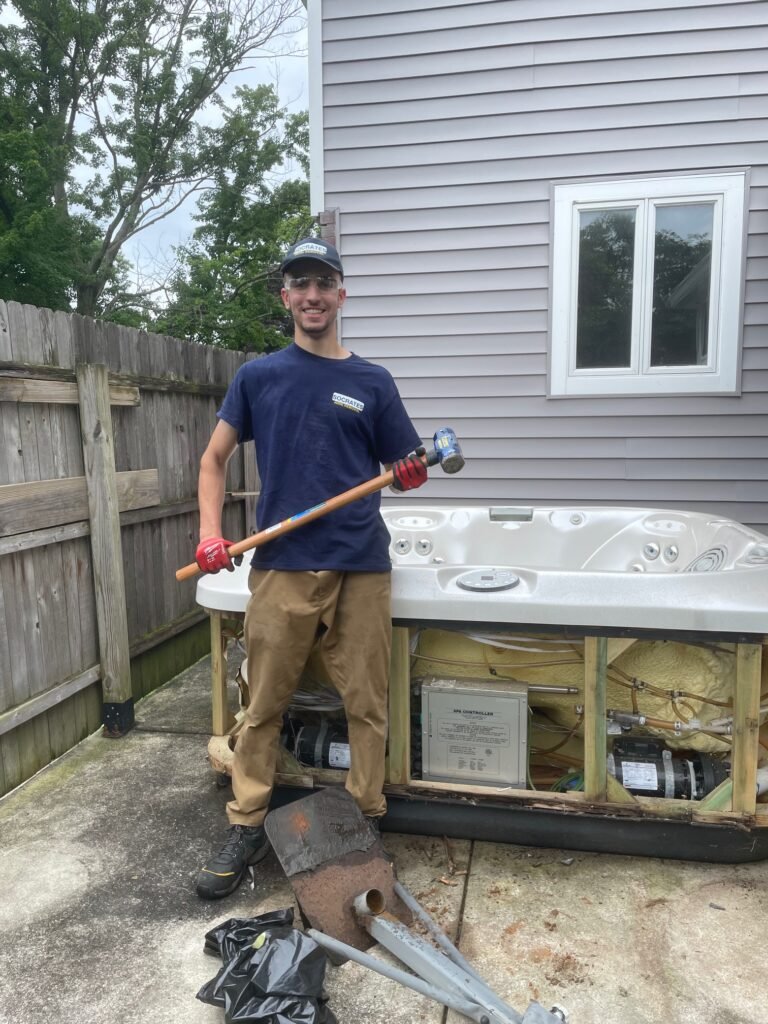 socrates junk removal owner in devon standing in front of hot tub before removal