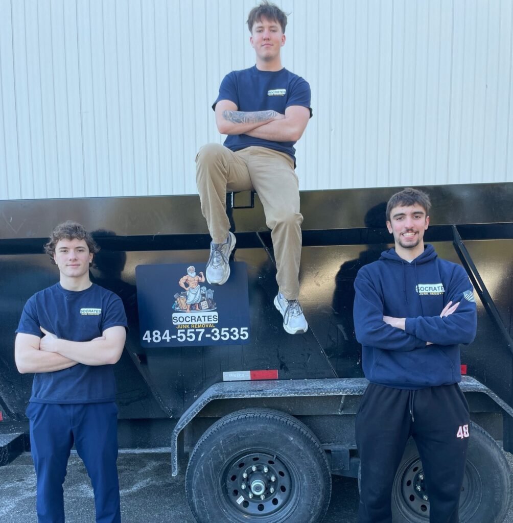 Socrates Junk Removal crew standing in front of branded dump trailer during junk removal service in Oaks PA