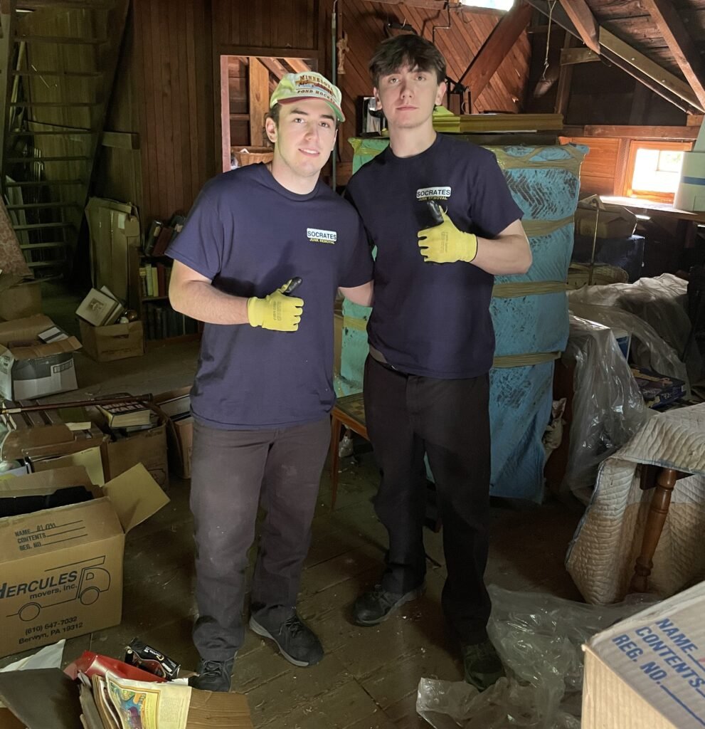 Socrates Junk Removal crew giving thumbs up during a hoarder cleanout in a Wayne PA attic